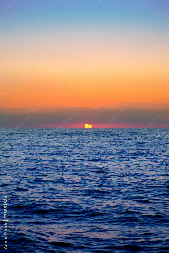 blue sea sunrise with sun in horizon