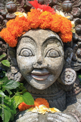 Carved stone statue with flower decoration