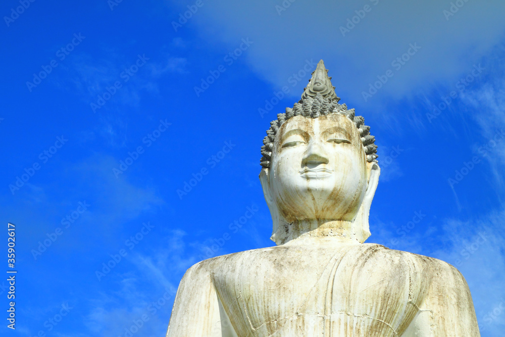 Half buddha statue on blue sky