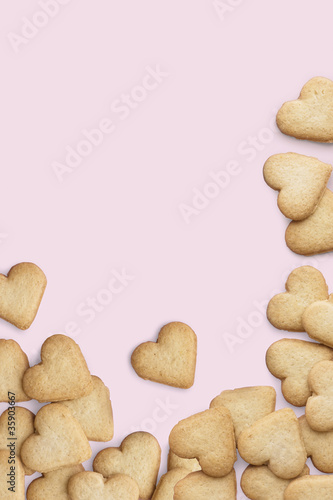 Heart-shaped cookies on pink background