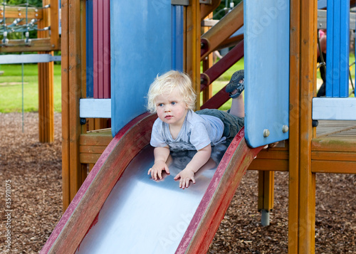 child playing on slide photo