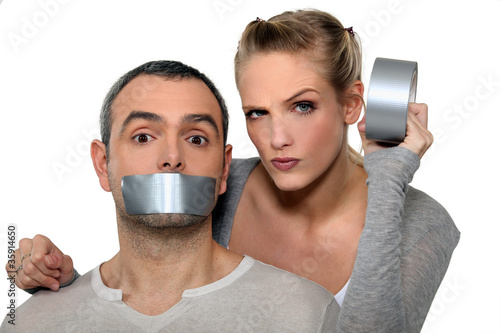 Woman taping-up mans mouth