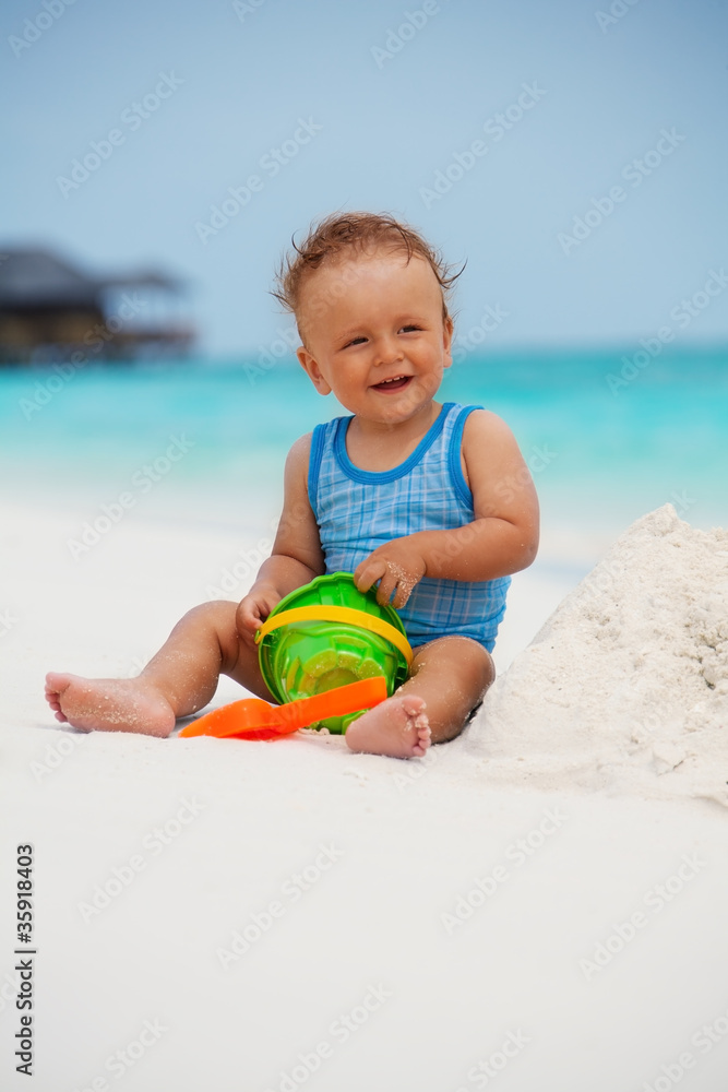 Kid playing with sand on the beach Kid playing with sand on the beach