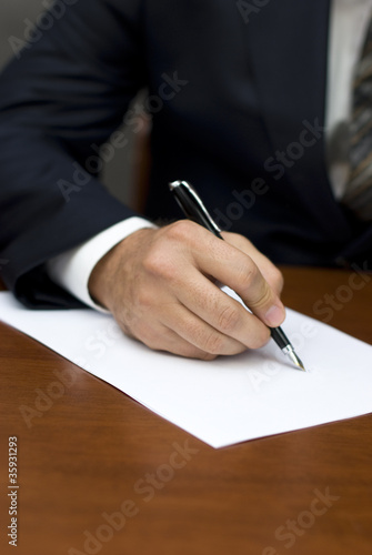 Businessman's hand writing on white sheets