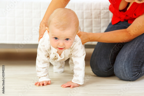 Εκτύπωση καμβά Mother helping cheerful baby learn to creep