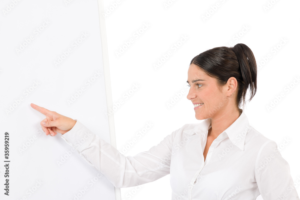 Happy businesswoman pointing at empty flip chart Happy businesswoman pointing at empty flip chart