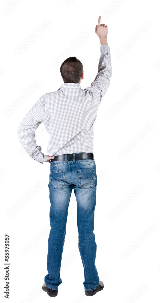 young man pointing at wall. rear view. young man pointing at wall. rear view.