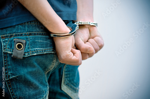 Fototapeta Young man in handcuffs