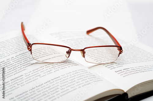 Reading glasses lying on the open book