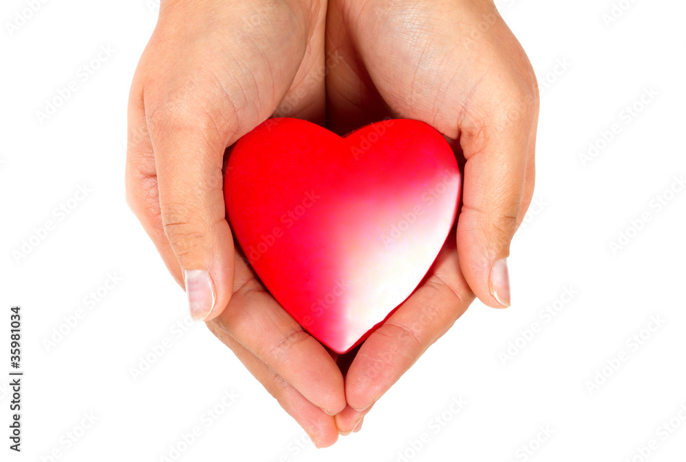 Female hands taking care of red heart Female hands taking care of red heart