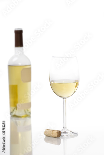 Glass of White Wine with Bottle in Background