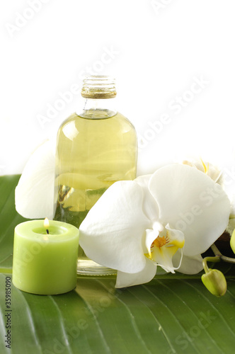 white orchid, bottles with essential oil, on banana leaf
