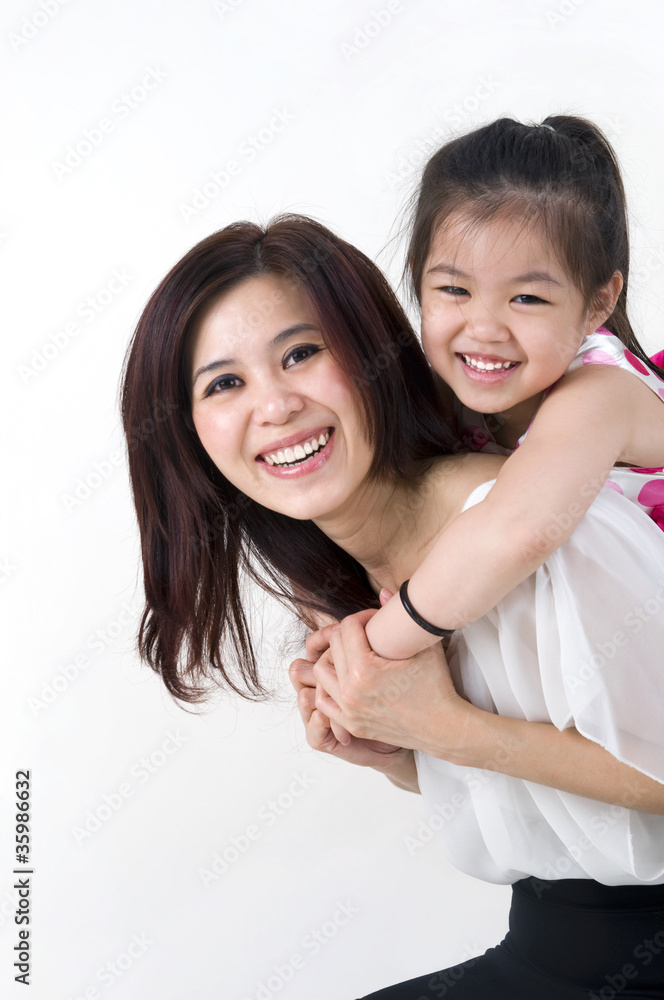happy asian mother giving her daughter a piggyback ride happy asian mother giving her daughter a piggyback ride