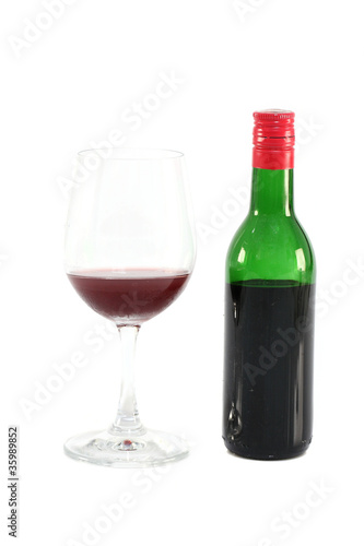 Bottle of red wine and grass isolated in white background
