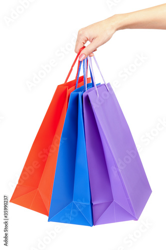 colorful shopping bags set in woman's hand isolated on white