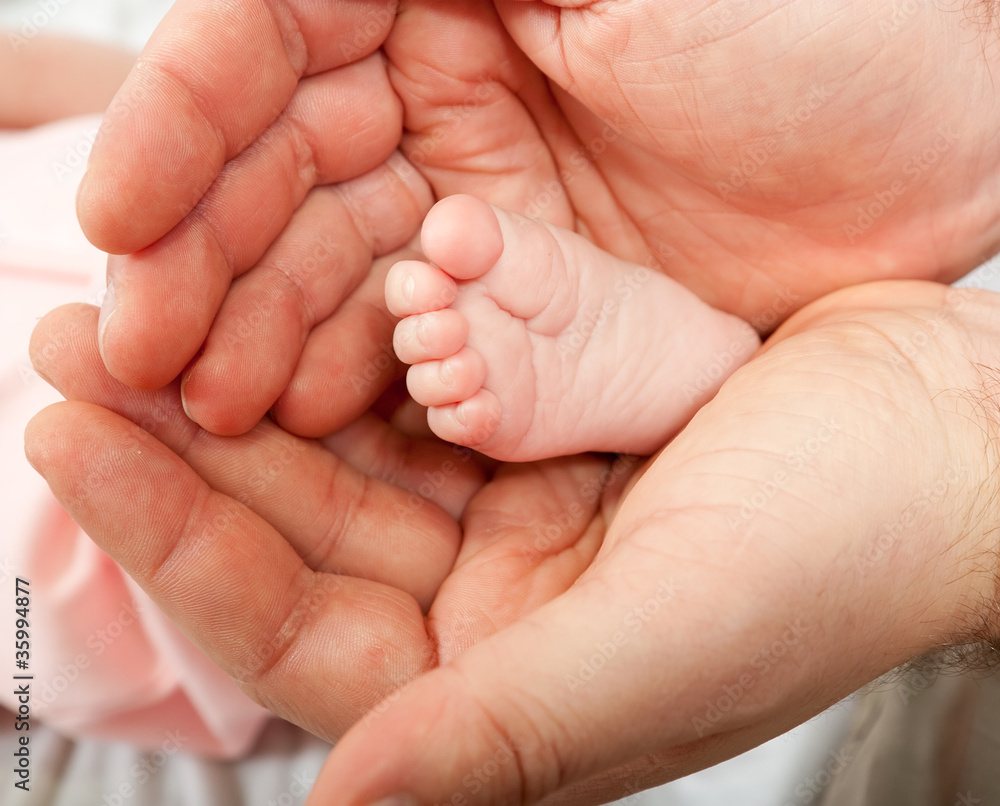 Baby's little foot in daddy's hand Baby's little foot in daddy's hand