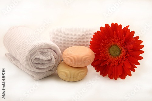 saponette con fiore e asciugamani su fondo bianco photo