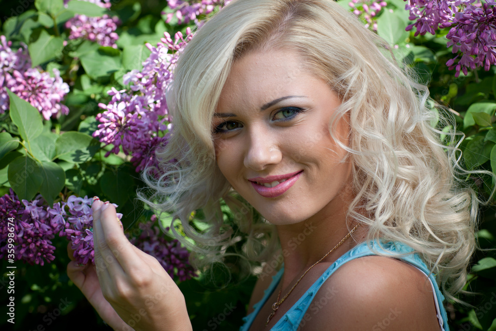 Naklejka premium Young blonde woman in the park