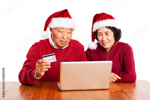 Senior Asian couple shopping online celebrating Christmas