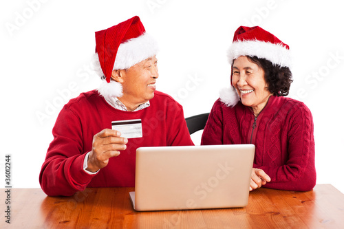 Senior Asian couple shopping online celebrating Christmas