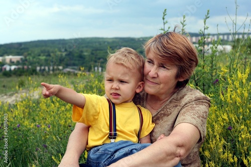 Grandchild with grandmother is showing forward by a finger