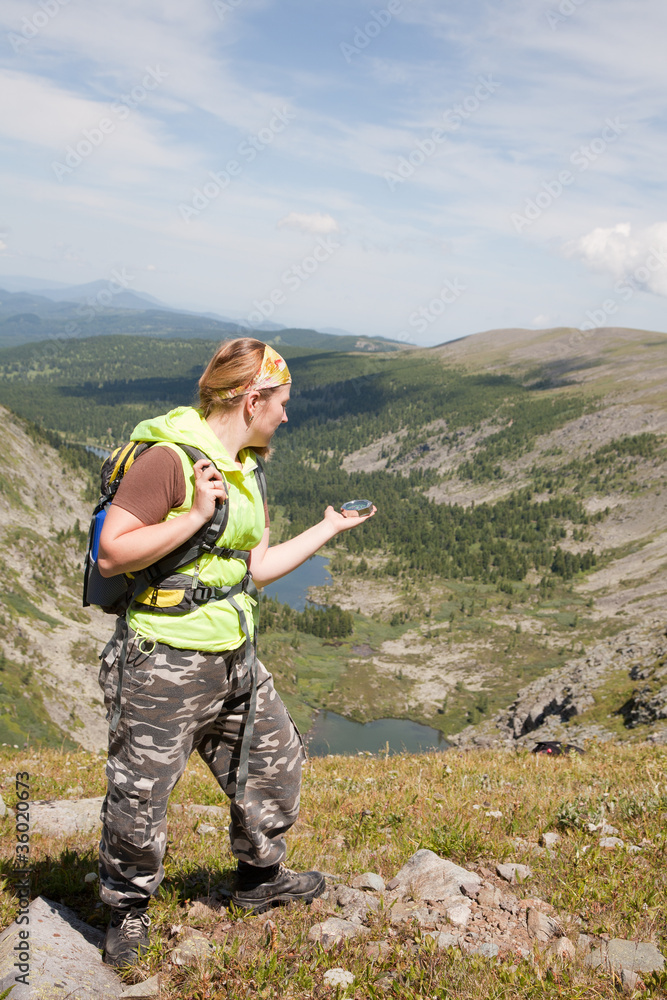 tourist in mountains with a compass in a hand