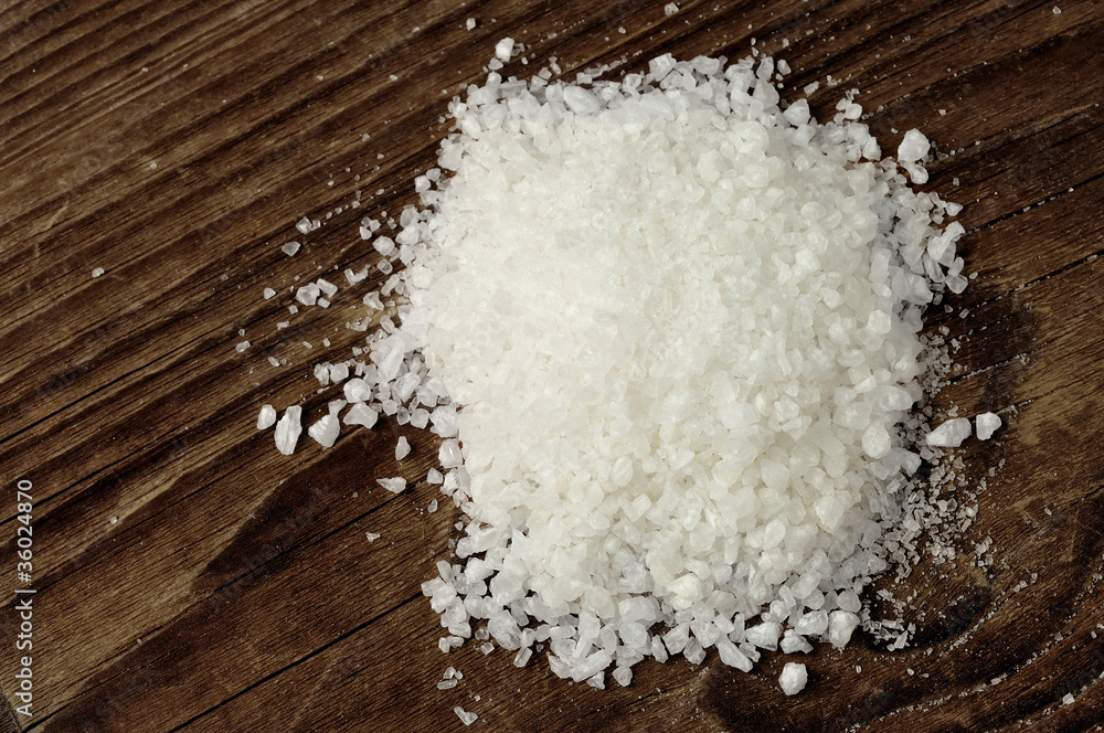 Coarse sea salt on a wooden table