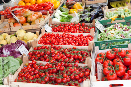 Fresh raw vegetables in wooden boxes at open street market close