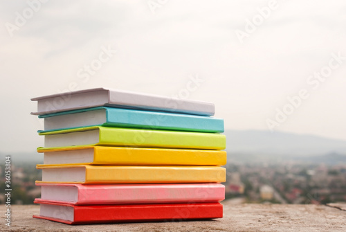 Obraz na płótnie Stack of colorful books laying outdoors w salonie