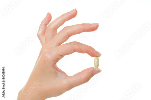 The capsule in hand on a white background.