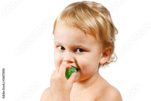 Little boy with green jelly candy on white background