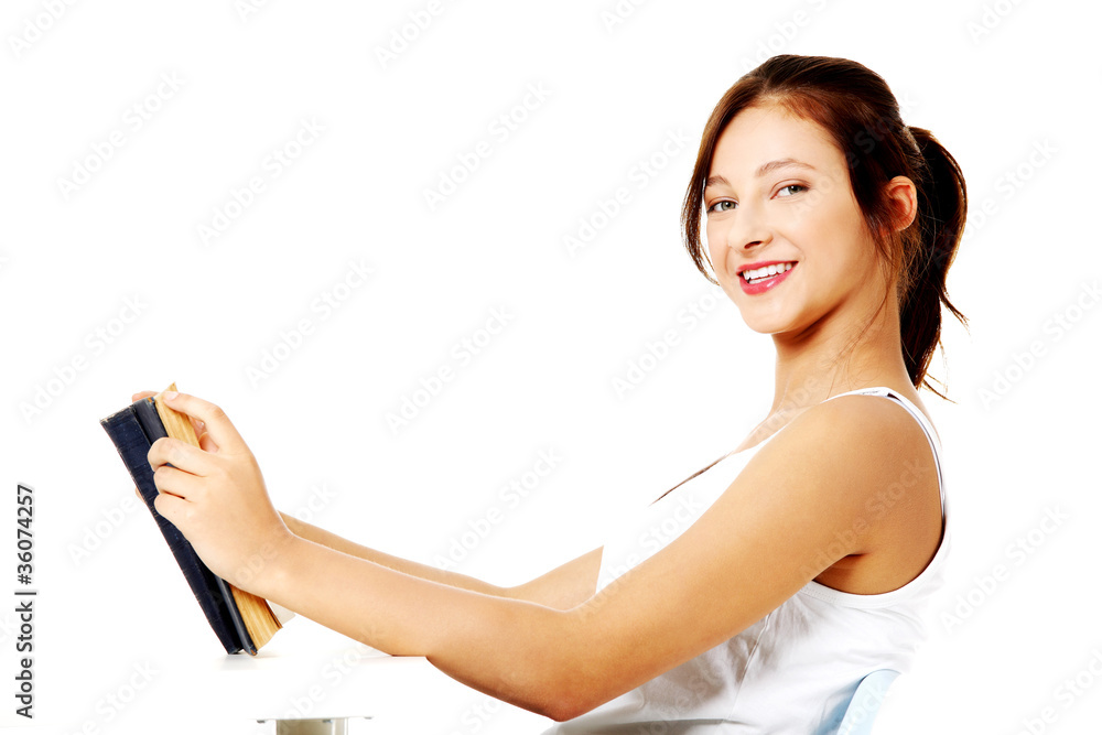 Sitting girl holding a book and smiling. Sitting girl holding a book and smiling.