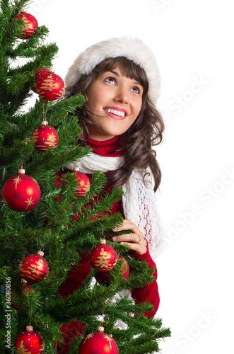 lachende Frau hinter Weihnachtsbaum schaut nach oben