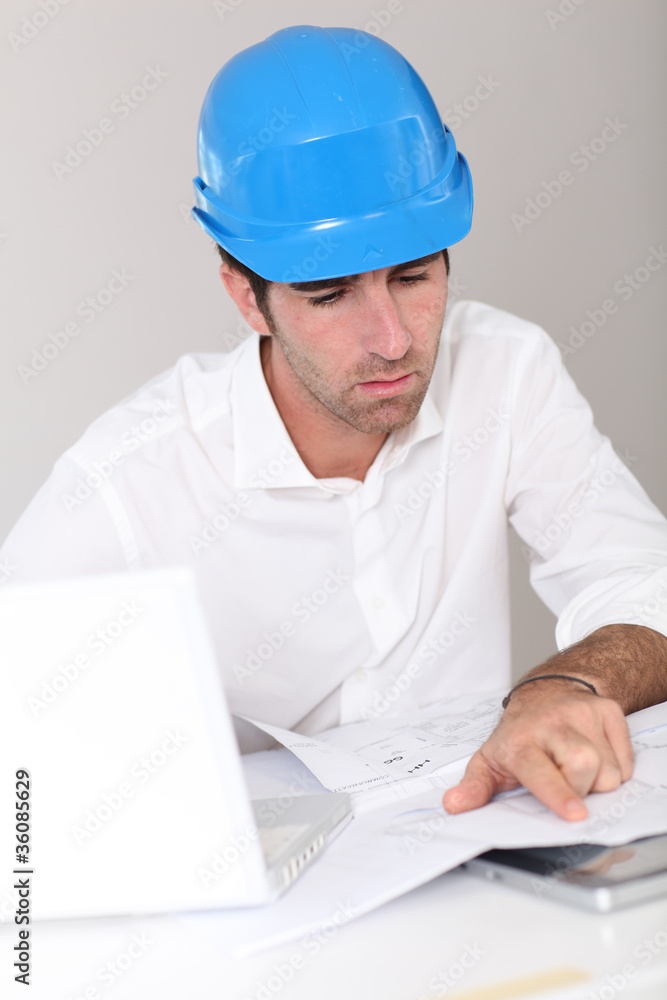 Site manager in office with security helmet Site manager in office with security helmet