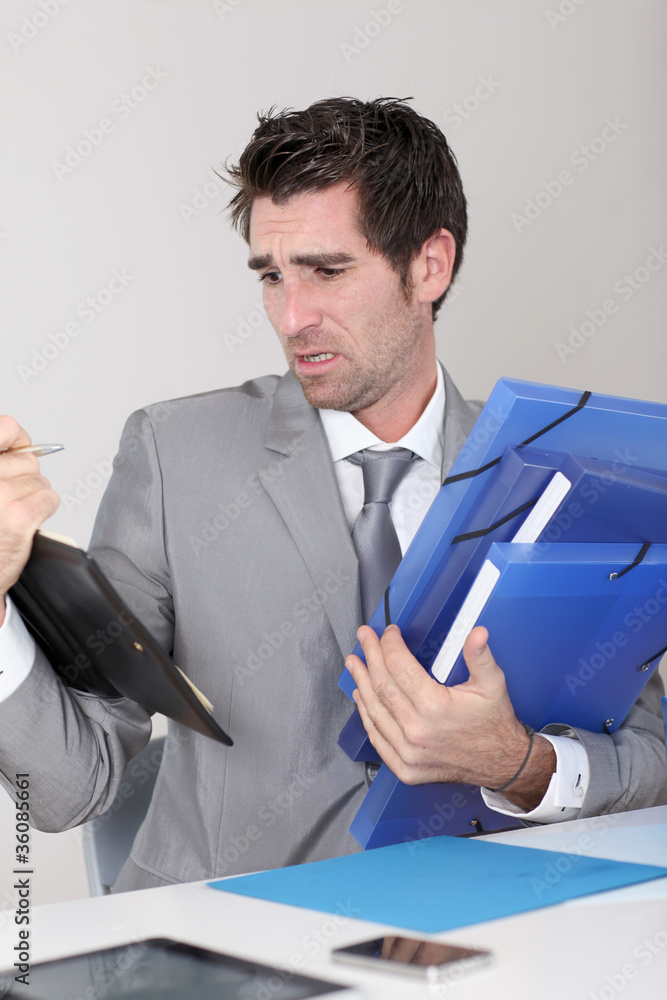 Businessman overwhelmed with work Businessman overwhelmed with work