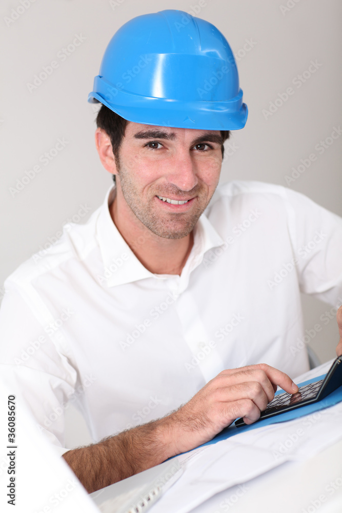 Site manager in office with security helmet Site manager in office with security helmet