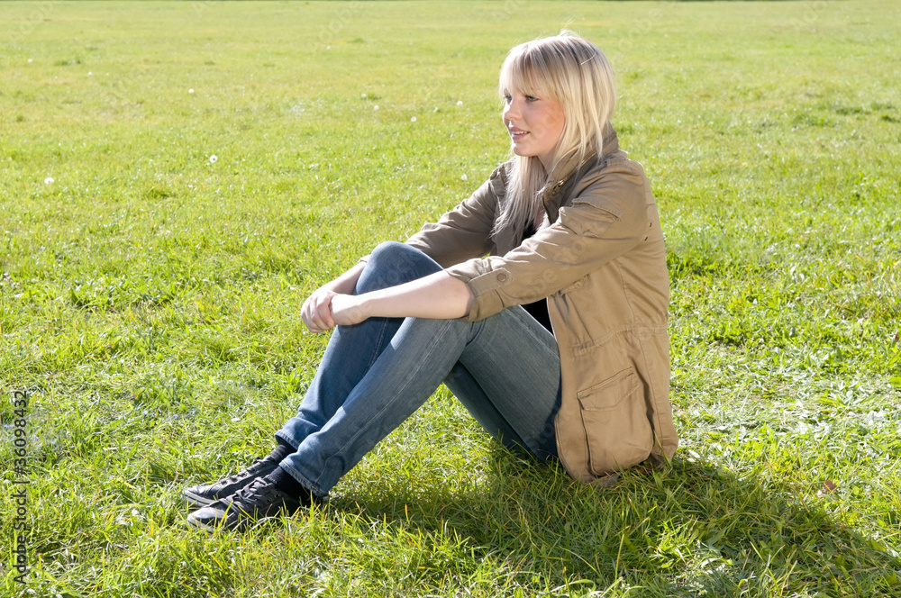 Fototapeta premium junge frau sitzt auf einer wiese