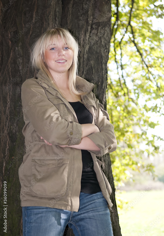 junge frau steht an einem baum junge frau steht an einem baum