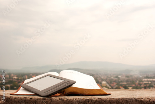 Obraz na płótnie Electronic book reader laying on the book outdoors w salonie