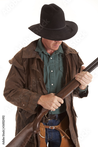cowboy looking down at shotgun