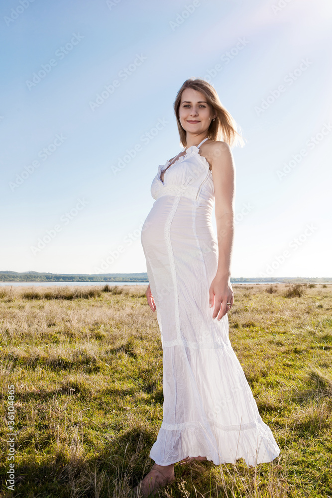 Pregnant woman standing on field Pregnant woman standing on field