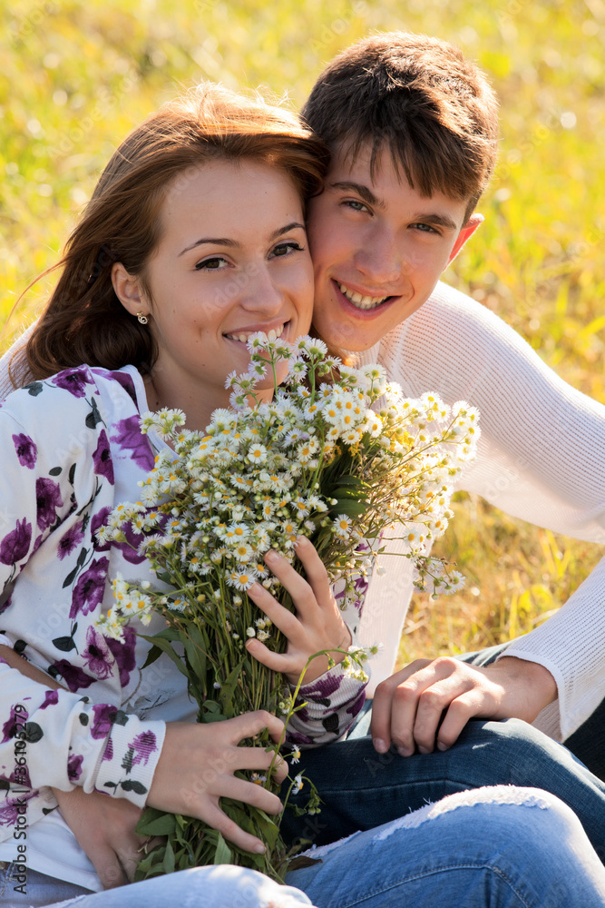 Love and affection between a young couple at the park in autumn Love and affection between a young couple at the park in autumn