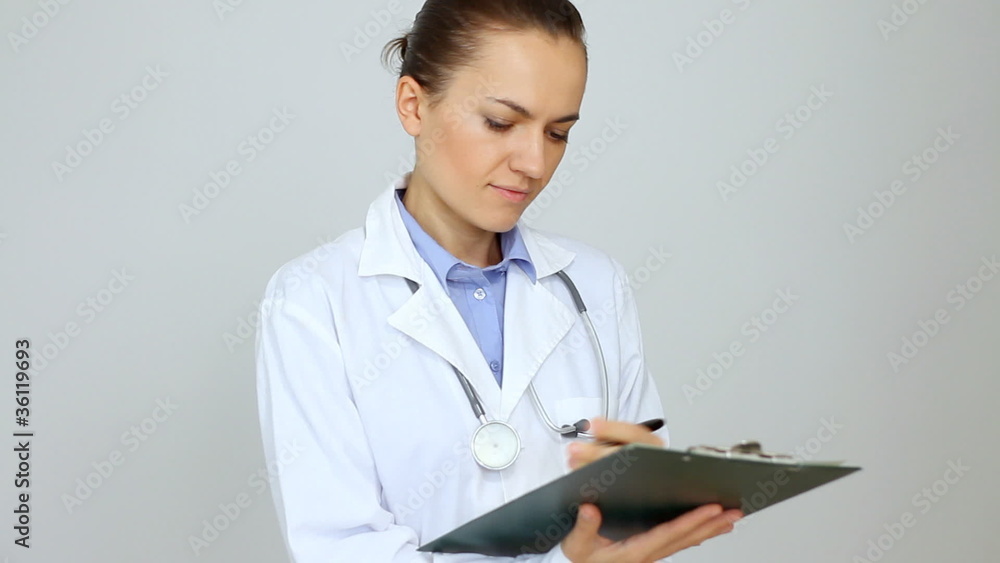 Happy female doctor with clipboard over grey background Happy female doctor with clipboard over grey background