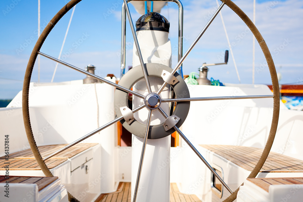 Naklejka premium A steering wheel on a boat with empty seats.