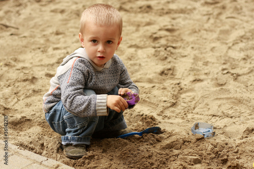 little boy playing in the sand