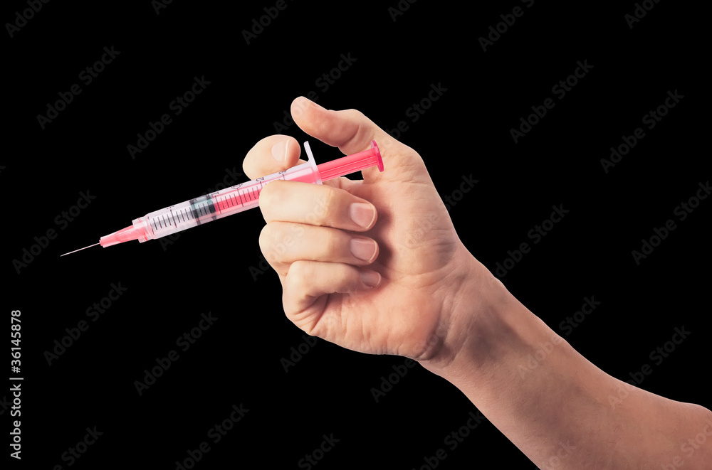 Syringe in man's hand isolated on black background Syringe in man's hand isolated on black background