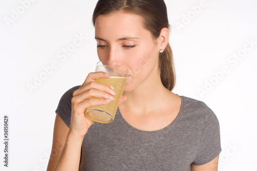 Junge Frau trinkt aus einem Glas