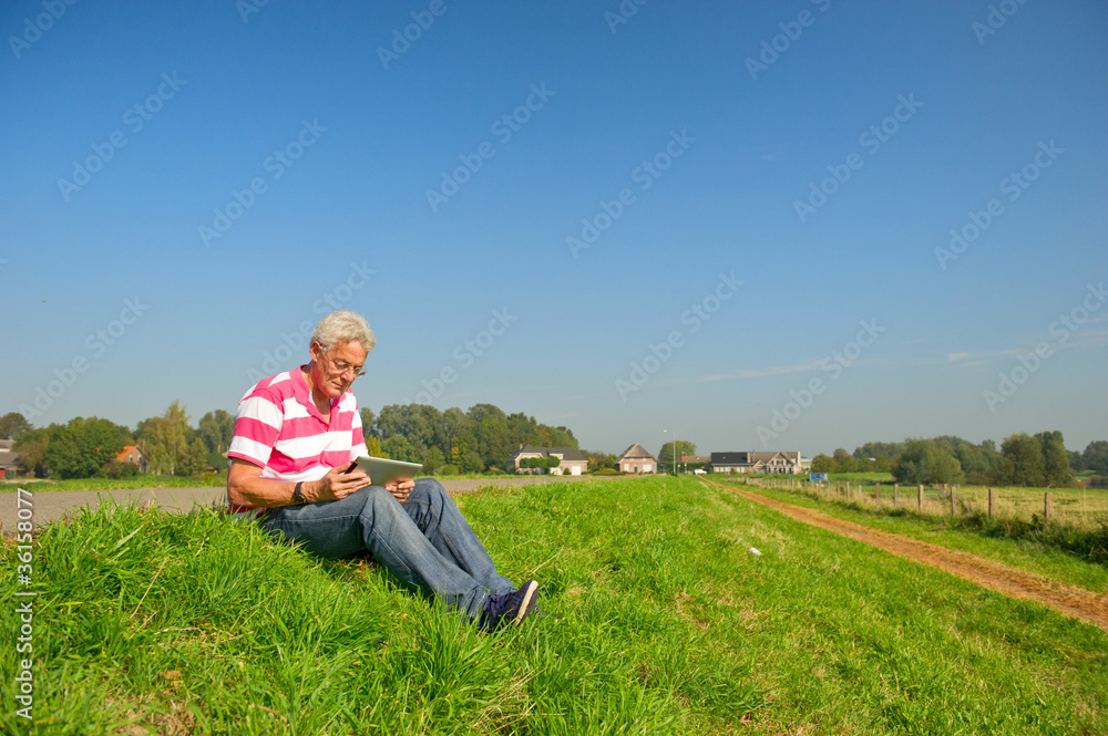 Senior with tablet PC outdoor