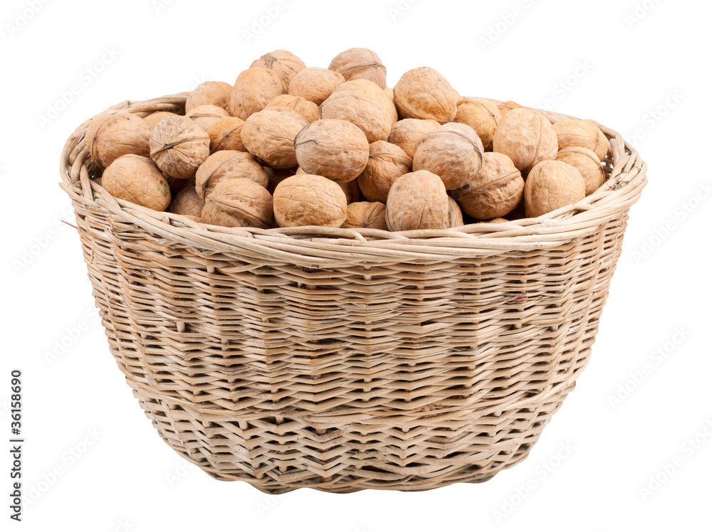 Walnuts in wooden basket on the white background Walnuts in wooden basket on the white background
