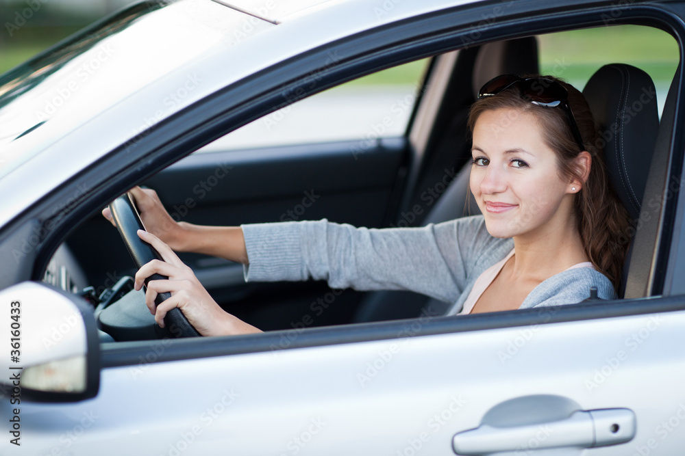 Pretty young woman driving her new car